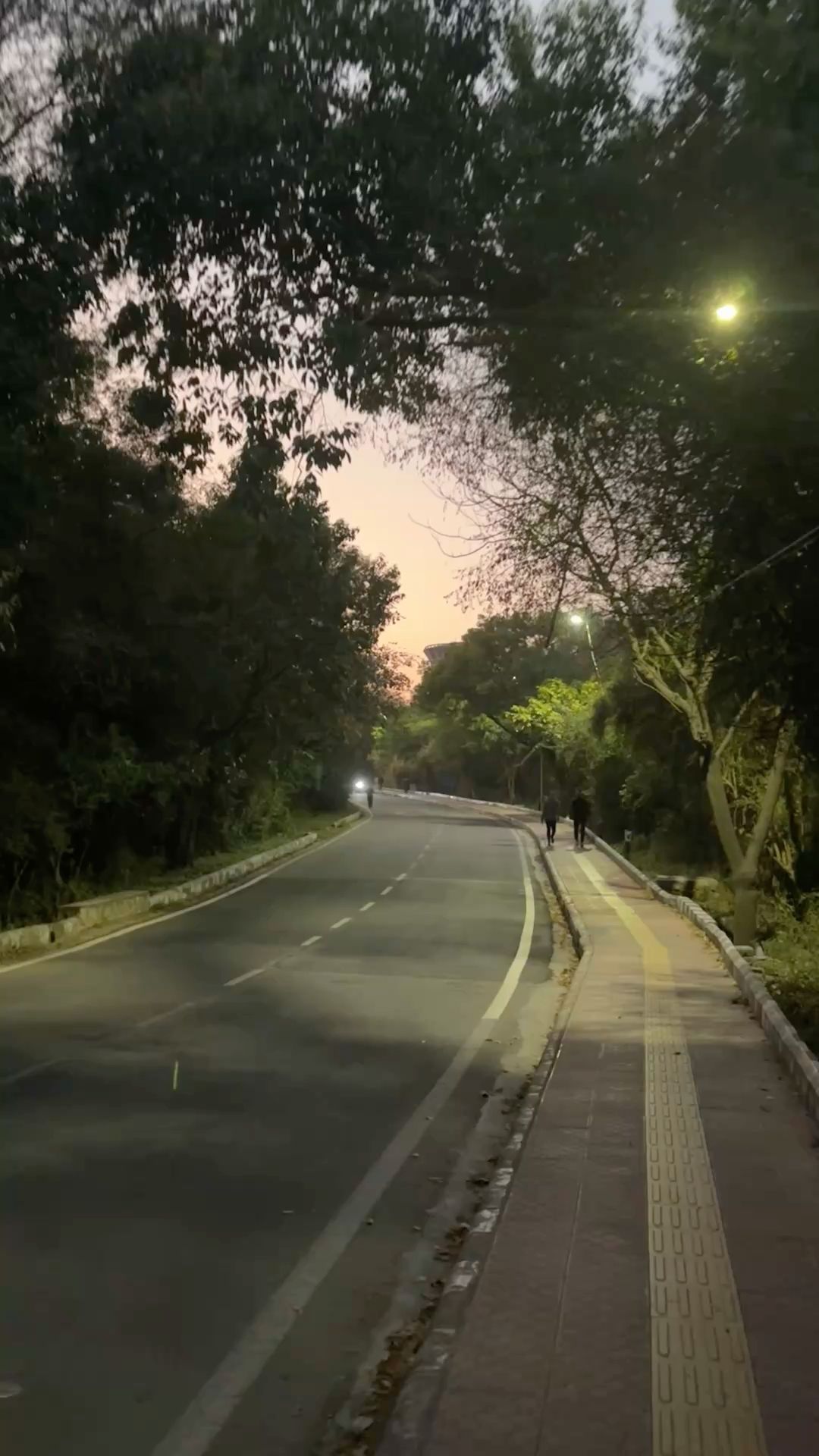 Coastal walkway blurred figures soft fog distant city silhouette